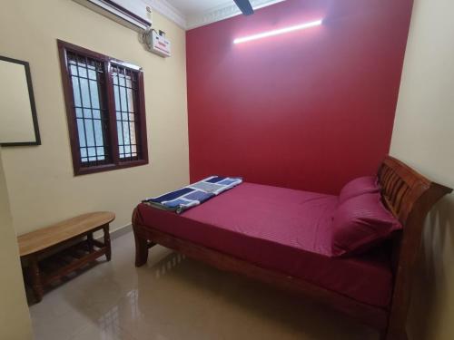 a bed in a room with a red wall at ZIA Villa in Puducherry