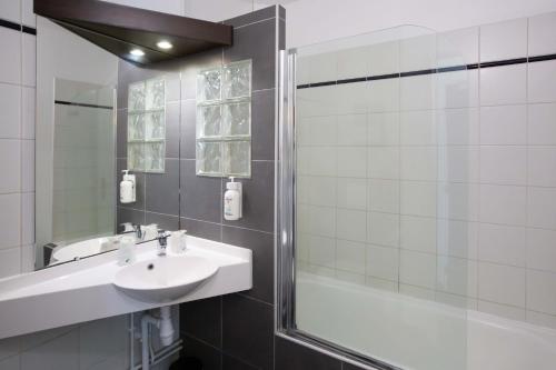 a bathroom with a sink and a shower at HOTEL l'EAUBONNE in Eaubonne