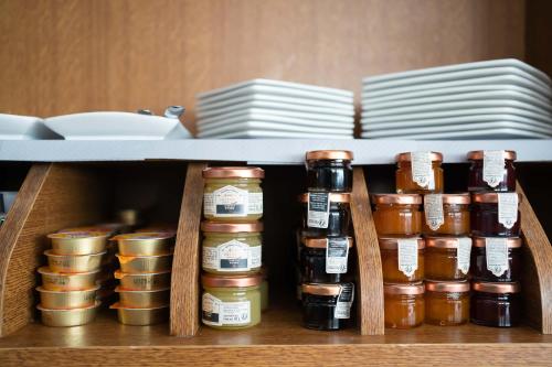 a shelf with jars and plates in a kitchen at HOTEL l'EAUBONNE in Eaubonne