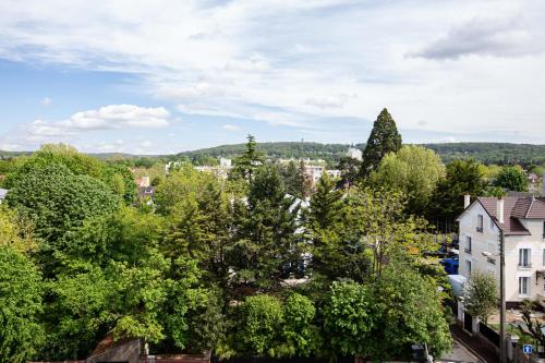 a view of a city with trees and houses at HOTEL l'EAUBONNE in Eaubonne