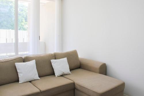 - un canapé avec deux oreillers dans le salon dans l'établissement Charming T3 with two balconies in Bagnolet, à Bagnolet