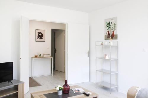 - un salon avec des murs blancs et un miroir dans l'établissement Charming T3 with two balconies in Bagnolet, à Bagnolet