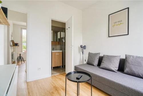 un salon avec un canapé et une table dans l'établissement Maison au calme pour 4 pers avec parking a 5 min du métro L7, à Villejuif