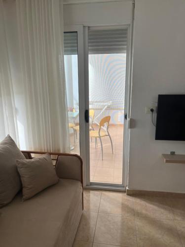 a living room with a couch and a sliding glass door at Bellavista Qerret Apartments in Golem