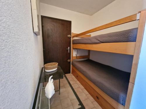 Cette petite chambre comprend 2 lits superposés et une porte. dans l'établissement Studio cœur de ville, proche des plages, vue mer, à Bandol