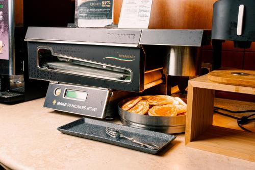 a toaster oven sitting on a counter with bread at Novotel Roma Est in Rome