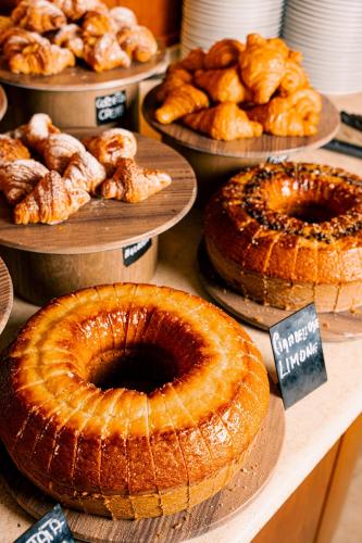 a display of pies and pastries on plates on a table at Novotel Roma Est in Rome