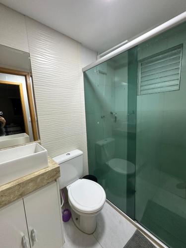 a bathroom with a toilet and a glass shower at Lindo Apartamento in Brasília