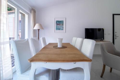 a dining room with a table and white chairs at Ermes by PortofinoHomes in Portofino