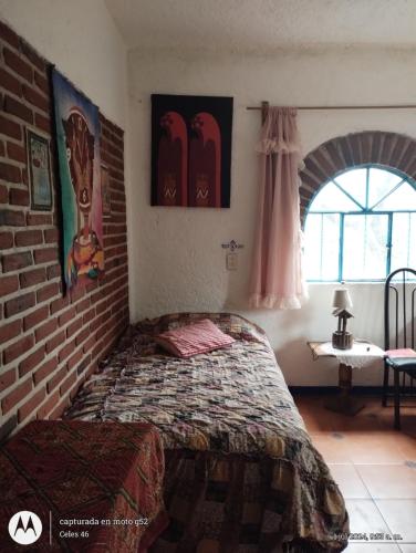a bedroom with a bed and a brick wall at Casa Ecológica Pablo in Curva La Pera