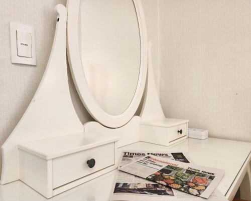 a bathroom with a mirror and a magazine on a table at Lucy Stay in Seoul