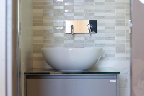 a bathroom sink with a bowl on a counter at Ermes by PortofinoHomes in Portofino