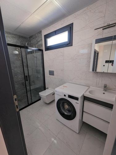 a bathroom with a washing machine and a sink at Villa Begonvil in Kuşadası