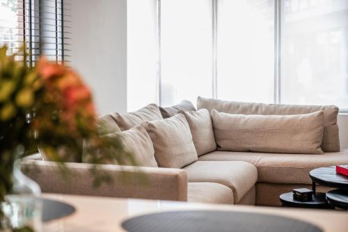 a living room with a couch and a table at Sejoylia Knokke: app 2ch luxueux au centre de KH in Knokke-Heist