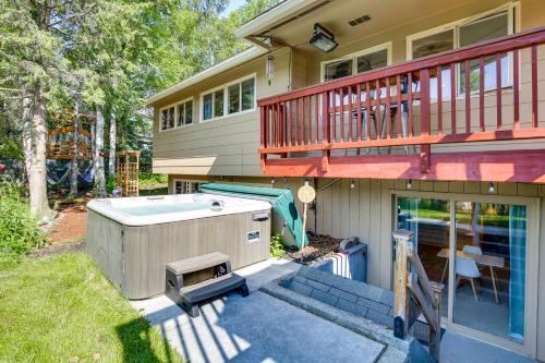 a house with a hot tub and a balcony at Spacious Eagle River Escape with Hot Tub and Views! in Eagle River