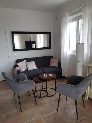 un salon avec un canapé, des chaises et une table dans l'établissement Vue mer exceptionnelle, à Cavalaire-sur-Mer