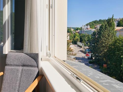 a window with a bench looking out at a street at IMPERIAL Apartments in Karlovy Vary