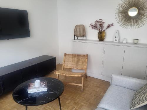 un salon avec une table basse et un canapé dans l'établissement Appart Nicette, à Courbevoie