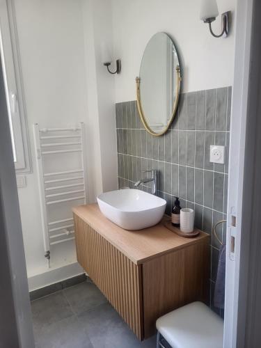 une salle de bain avec un lavabo blanc et un miroir dans l'établissement Appart Nicette, à Courbevoie