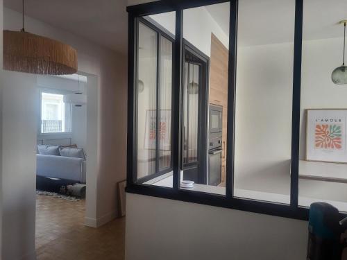 - un salon avec trois fenêtres et un canapé dans l'établissement Appart Nicette, à Courbevoie