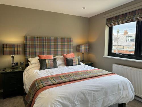 a bedroom with a large bed and a window at Victoria Cottage, Cullercoats in Cullercoats