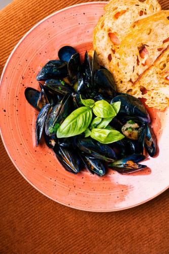 a plate of mussels and bread on a table at Novotel Roma Est in Rome