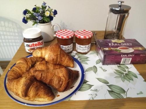 a table topped with a plate of croissants and jams at Park Apartment in Kraków