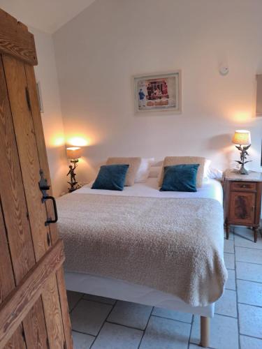 une chambre avec un lit avec deux oreillers bleus dans l'établissement Chambres d hotes proche Macon, à Grièges