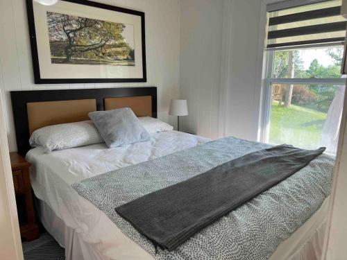 een slaapkamer met een groot bed en een raam bij Beachfront Cabin #5- Maijac Resort & Marina in Magnetawan