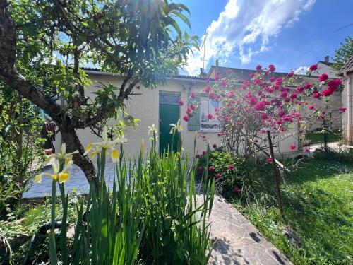 a garden with flowers in front of a house at Petite maison proche l'aéroport Charles de Gaules, parc Astérix et Stade de France in Goussainville