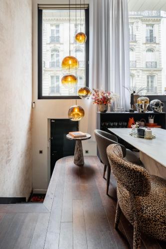 une salle à manger avec une table et des chaises dans l'établissement Veeve - Contemporary Excellence, à Paris