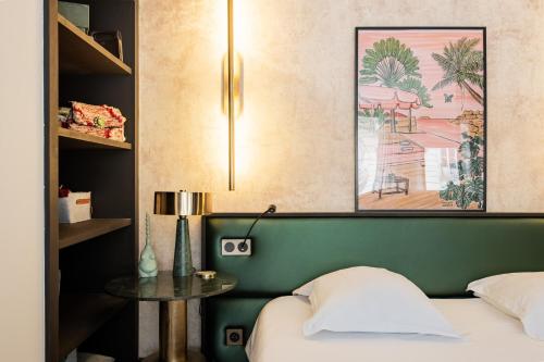 - une chambre avec un lit doté d'une tête de lit verte et d'une table dans l'établissement Veeve - Contemporary Excellence, à Paris