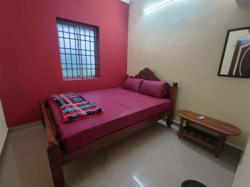 a small bedroom with a purple bed with a window at ZIA Villa in Puducherry