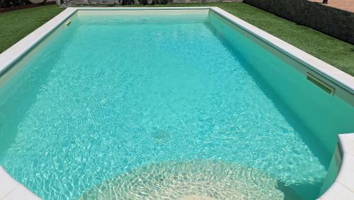 a swimming pool with blue water in a yard at Villa Teresa in Oschiri