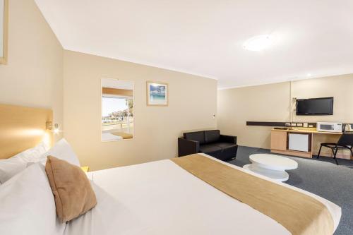 a hotel room with a large bed and a bathroom at Ciloms Airport Lodge Melbourne Airport in Melbourne