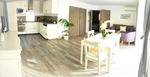 a kitchen and living room with a table and a dining room at Maison confortable à La Ciotat avec terrasse privée in La Ciotat