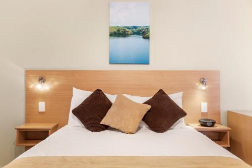 a bedroom with a white bed with two pillows at Ciloms Airport Lodge Melbourne Airport in Melbourne