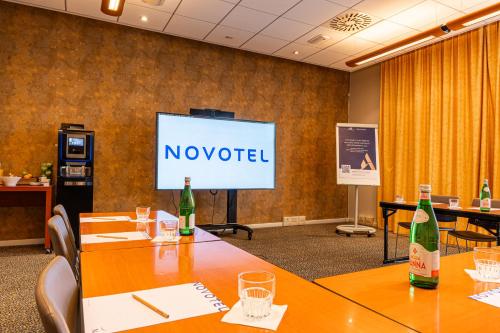 a conference room with two tables and a screen with no yielded at Novotel Roma Est in Rome
