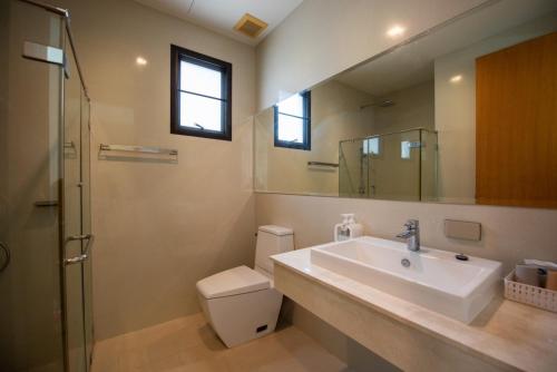 a bathroom with a sink and a toilet and a mirror at Lake paradise villa khaoyai LB4 in Ban Rai Khlong Sai