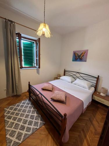 a bedroom with a bed and a window at Apartments Renata in Pučišća