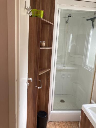 une douche dans une salle de bain avec une porte vitrée dans l'établissement mobil home L escale, à Meschers-sur-Gironde