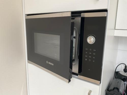 a black microwave oven in a kitchen at Aristoteles Apartments in Scheveningen
