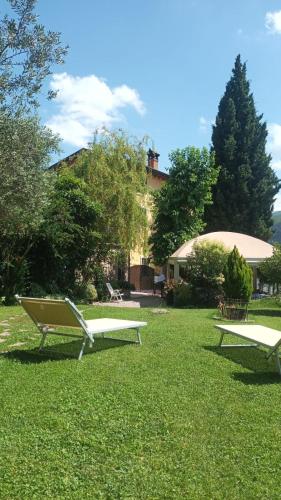two benches sitting in the grass in a park at Relais San Michele in Rivoli Veronese