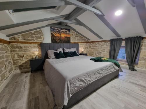 a bedroom with a large bed and a stone wall at Villa Vega in Višnjan