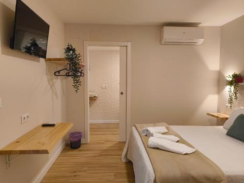 a bedroom with a bed with towels on it at Villa Galicia (Padrón) in Padrón
