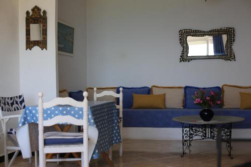 a living room with a blue couch and a table at Sérénité Marine in Fnidek