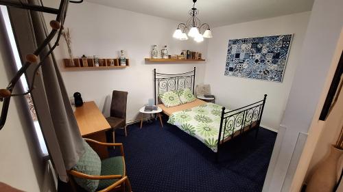 a bedroom with a bed and a table and a desk at Leipa Apart in Česká Lípa
