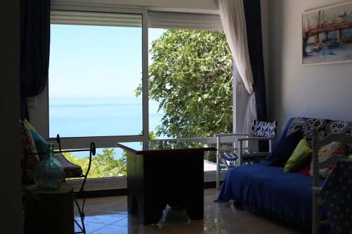 a living room with a couch and a large window at Sérénité Marine in Fnidek