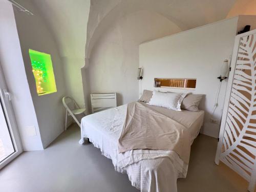 Un dormitorio con una cama en una habitación blanca. en L'Arco delle Fogge - Suite con Terrazzo Esclusivo, en Fasano
