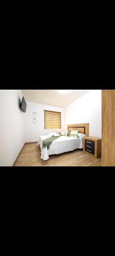 a large bedroom with a large bed and a window at Alojamiento el halcon in Santoña